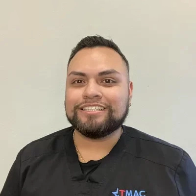 Rehab Director Hector Montano Smiling In Front Of Tan Backdrop